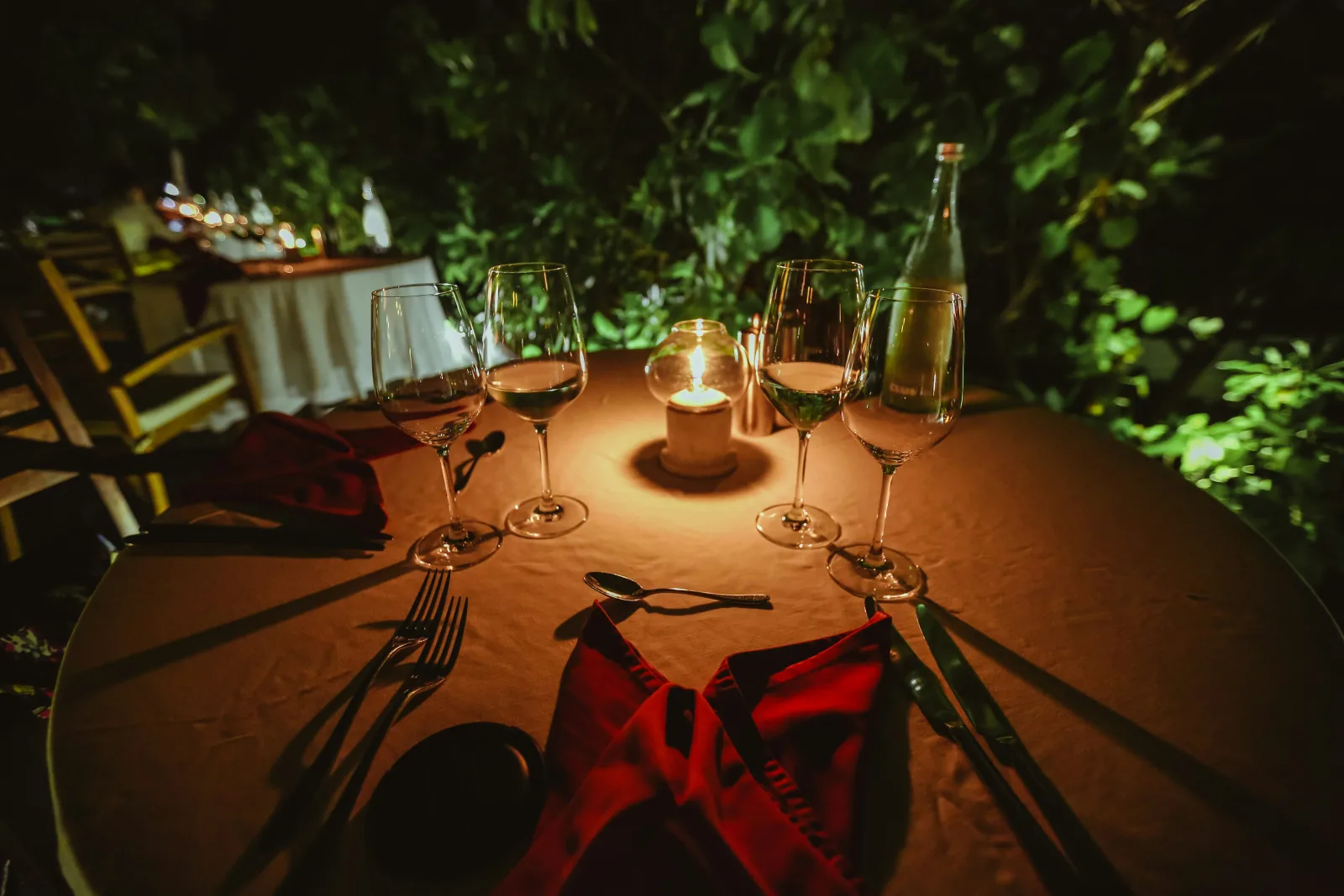 Candlelit private dinner table arranged outdoors at a safari camp