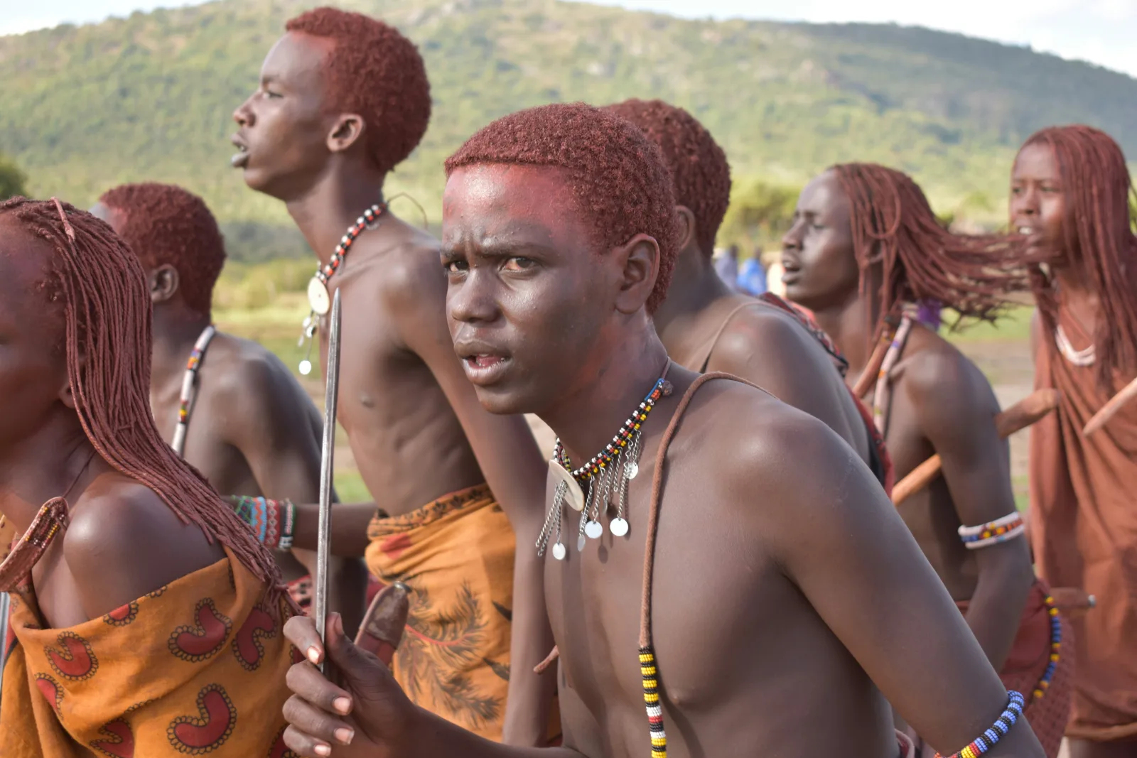 Maasai community members performing in traditional red clothing